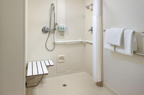 a bathroom with a shower with a bench in it at Courtyard Orlando International Drive/Convention Center in Orlando