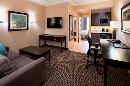 a living room with a couch and a desk in a hotel room at Delta Hotels by Marriott Guelph Conference Centre in Guelph
