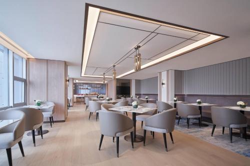 a restaurant with tables and chairs and a large chandelier at Nanning Marriott Hotel in Nanning