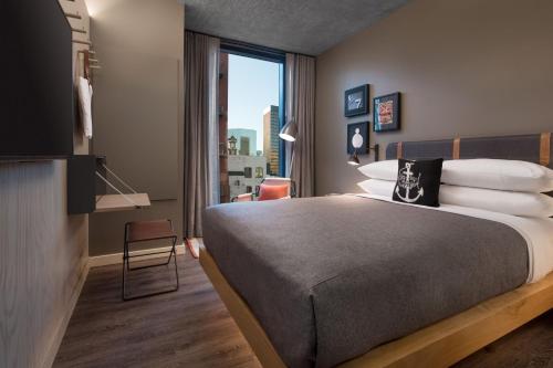 a hotel room with a bed and a large window at Moxy San Diego Gaslamp Quarter in San Diego