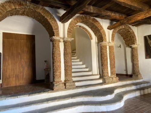 a building with three arches and a staircase at B&B Palazzo Pancaro in Altomonte