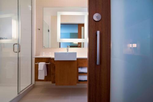 ein Bad mit einem Waschbecken, einem Spiegel und einer Dusche in der Unterkunft SpringHill Suites by Marriott Wisconsin Dells in Wisconsin Dells