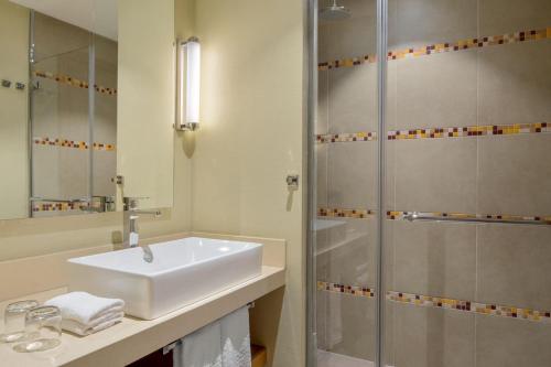 a bathroom with a sink and a shower at Four Points by Sheraton Ikot Ekpene in Ikot Ekpene