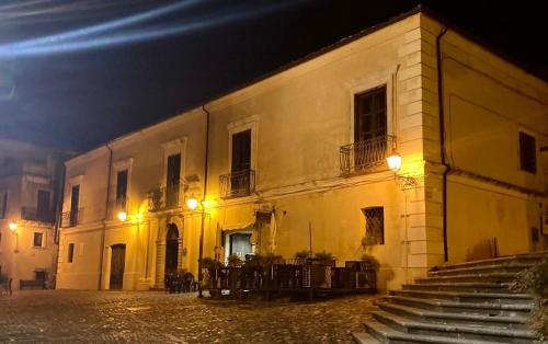 a building with tables and chairs outside at night at B&B Palazzo Pancaro in Altomonte