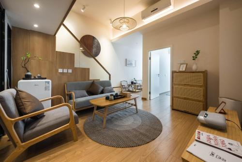 uma sala de estar com um sofá e uma mesa em WESU Apartment Shenzhen Futian Bagualing Branch em Shenzhen