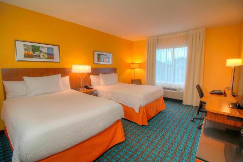 a hotel room with two beds and a desk at Fairfield Inn & Suites By Marriott Jupiter in Jupiter