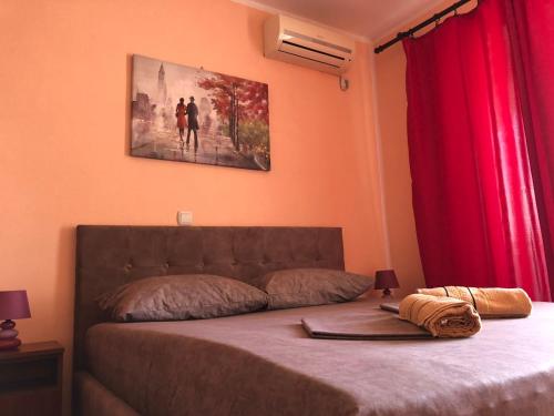 a bedroom with a bed with red curtains at Guest House Green Garden in Ulcinj