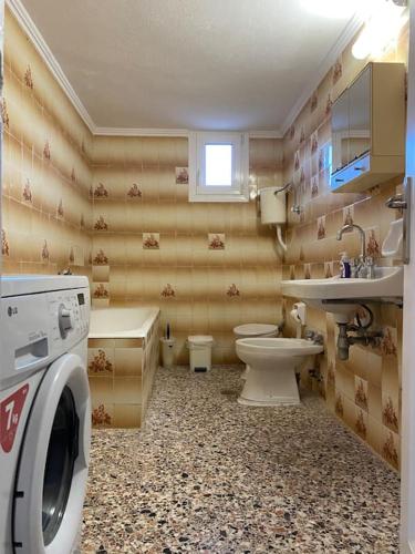 a bathroom with a toilet sink and a washing machine at Case di Stavros 2 in Pylos