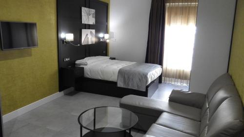 a hotel room with a bed and a couch at Apartamentos Las Palmeras in Palma del Río
