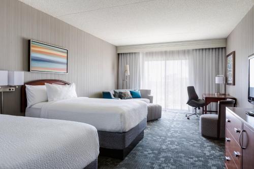 スコッツデールにあるCourtyard by Marriott Scottsdale Old Townのベッド2台とデスクが備わるホテルルームです。