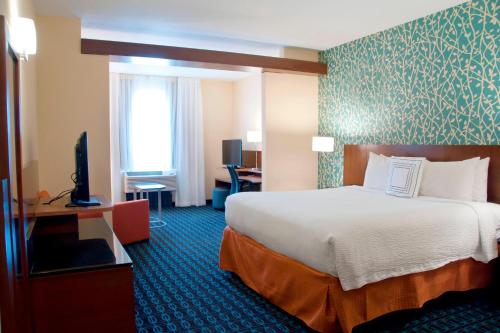 a hotel room with a bed and a flat screen tv at Fairfield Inn & Suites by Marriott Des Moines Urbandale in Urbandale