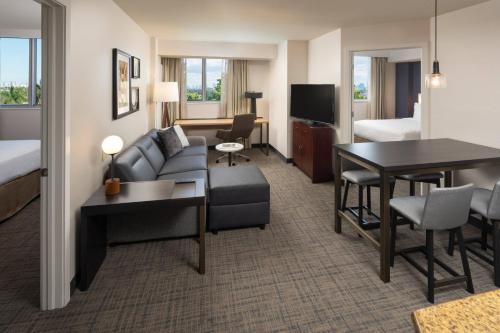 a hotel room with a living and dining room at Residence Inn by Marriott Miami Airport in Miami