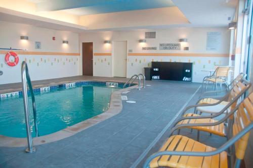Urbandale的住宿－萬豪梅因厄本代爾費爾菲爾德客棧及套房酒店，酒店客房的大型游泳池配有椅子