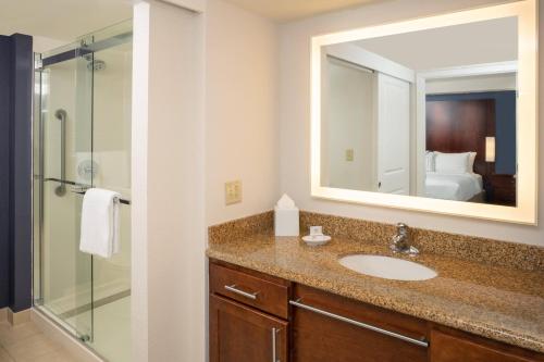 a bathroom with a sink and a shower and a mirror at Residence Inn by Marriott Miami Airport in Miami