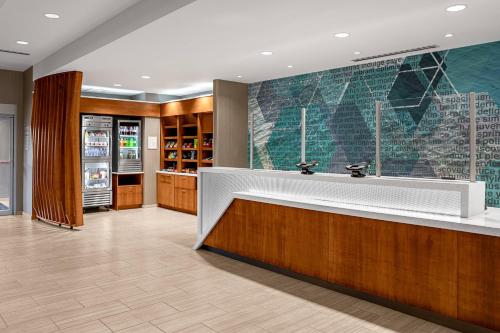 eine Restaurantlobby mit einer großen weißen Theke und Holz in der Unterkunft SpringHill Suites by Marriott Savannah Richmond Hill in Richmond Hill