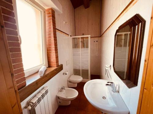 uma casa de banho com um lavatório, um WC e uma janela. em B&B Madre Vita em Belvedere