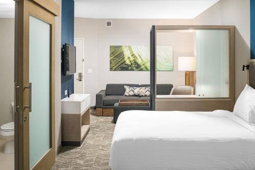 SpringHill Suites by Marriott Savannah Richmond Hill في ريتشموند هيل: فندق غرفه بسرير وصاله