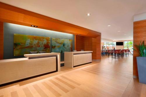 a lobby with tables and chairs and a painting on the wall at Delta Hotels by Marriott Anaheim Garden Grove in Anaheim