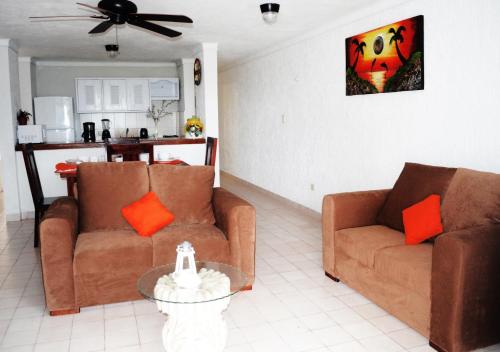 un salon avec deux canapés et une table dans l'établissement Arrecifes Suites, à Puerto Morelos