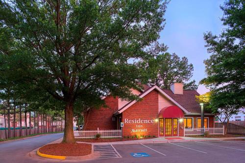 a red brick building with a tree in front of it at Residence Inn Richmond West End in Richmond