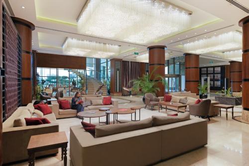 a lobby with couches and tables in a building at Ramada by Wyndham Erbil Gulan Street in Erbil