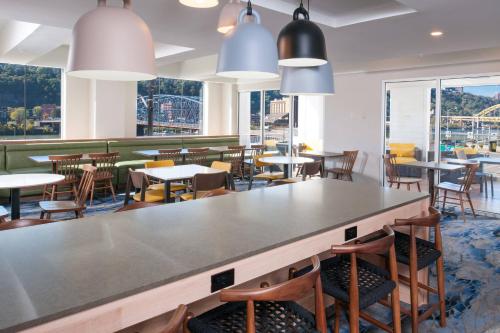 a dining room with tables and chairs and windows at Fairfield by Marriott Pittsburgh Downtown in Pittsburgh