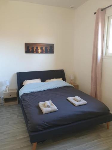 una camera da letto con un letto e due asciugamani di Appartement neuf, très lumineux a Hautot-sur-Mer