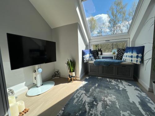 uma sala de estar com uma grande janela e uma televisão de ecrã plano em River Vista Retreat - Luxury duplex Apt - Views - Parking - Cycle storage - Spa access option em Backbarrow