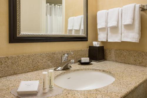 a bathroom with a sink and a mirror and towels at Courtyard Costa Mesa South Coast Metro in Santa Ana