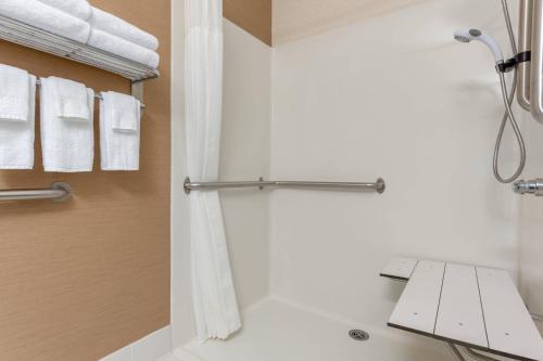 a bathroom with a shower with white towels at Fairfield Inn & Suites Stevens Point in Stevens Point