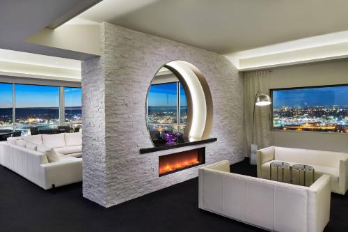 a living room with a fireplace and white furniture at The Davenport Grand, Autograph Collection in Spokane