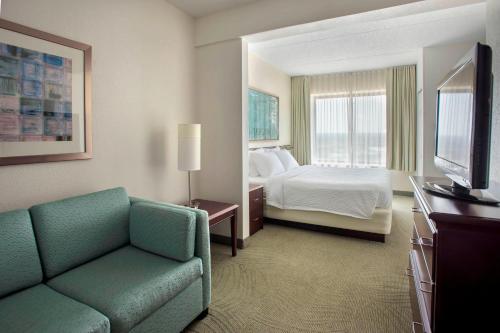 プリマス・ミーティングにあるSpringHill Suites Philadelphia Plymouth Meetingのベッド、ソファ、テレビが備わるホテルルームです。