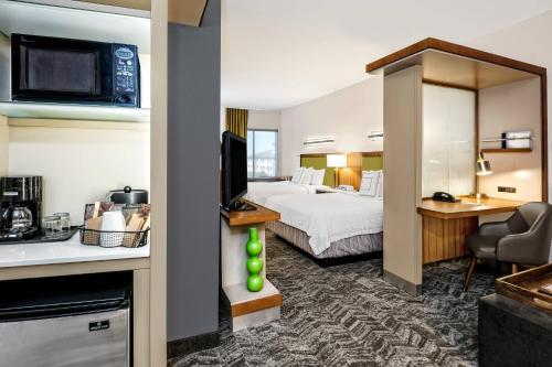 a hotel room with a king bed and a kitchen at SpringHill Suites by Marriott San Antonio SeaWorld®/Lackland in San Antonio