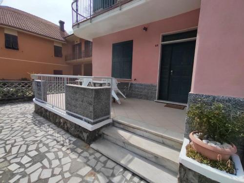 een balkon van een roze huis met een patio bij Il Ciliegio in Chiama