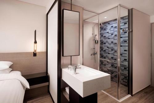 a bathroom with a sink and a glass shower at Fairfield by Marriott Busan in Busan