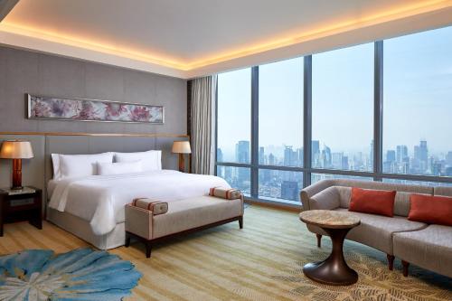 um quarto de hotel com uma cama e um sofá em The Westin Jakarta em Jakarta