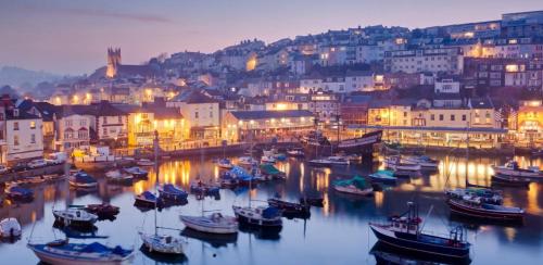 a group of boats in a harbor at night at Plain Sailing 2 min walk to the harbour amazing location in Brixham