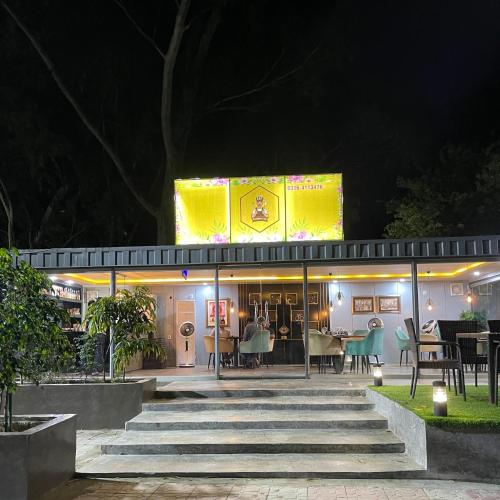 a restaurant at night with tables and chairs at PINETOP RESORT in Khanpur