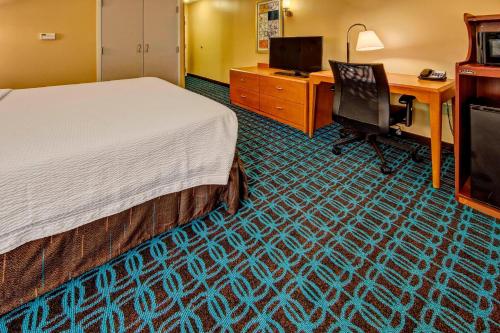 a hotel room with a bed and a desk and a computer at Fairfield Inn & Suites Memphis Olive Branch in Olive Branch