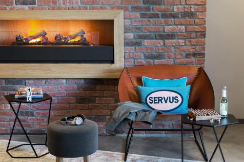 a chair with a pillow in front of a fireplace at Moxy Munich Ostbahnhof in Munich