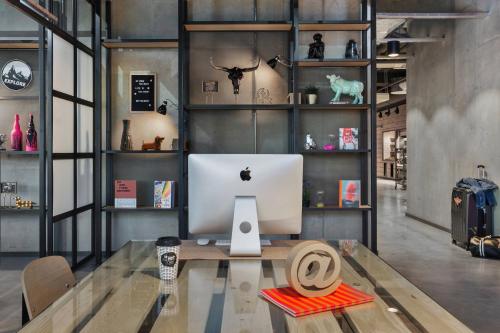 an office with a computer on a wooden table at Moxy Munich Ostbahnhof in Munich