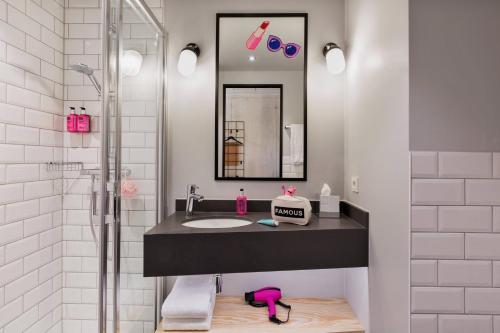 a bathroom with a sink and a shower at Moxy Munich Ostbahnhof in Munich