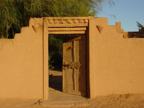 an old wooden door in a wall at Dar Paru in Mhamid