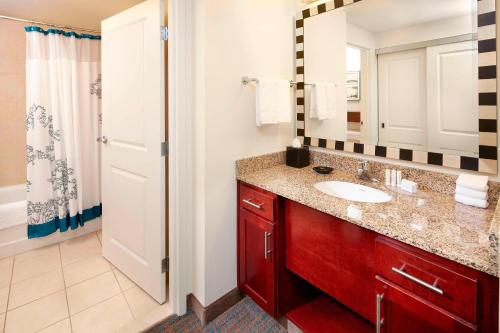 a bathroom with a sink and a mirror and a shower at Residence Inn Columbus Downtown in Columbus