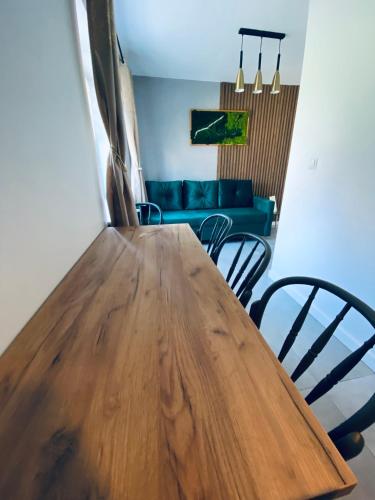 a wooden table in a living room with a couch at Apartamenty Majka in Zator