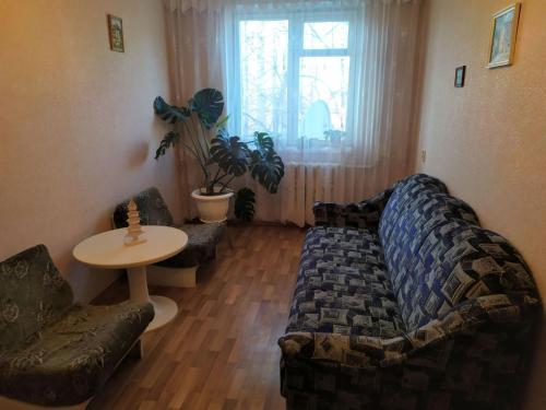 salon z kanapą i stołem w obiekcie Квартира біля залізничного вокзалу w mieście Winnica
