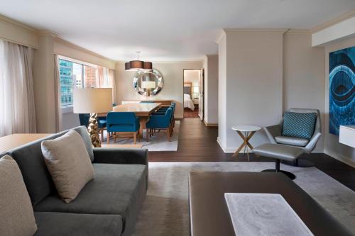 a living room with a couch and a dining room at Sheraton Ottawa Hotel in Ottawa