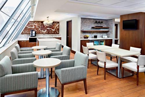 a restaurant with tables and chairs and a kitchen at Sheraton Ottawa Hotel in Ottawa