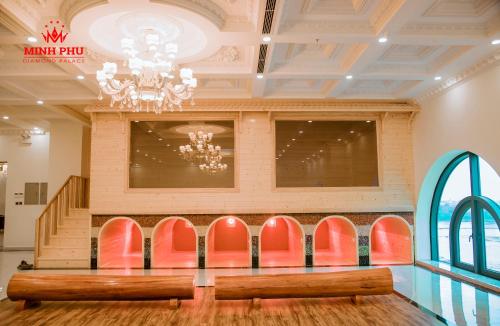 a row of red chairs in a lobby with a chandelier at Khách sạn Minh Phú Diamond Palace in Diễn Châu