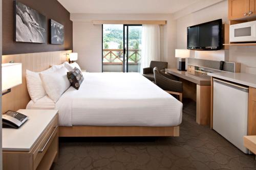 Delta Hotels by Marriott Whistler Village Suites في ويسلار: غرفة في الفندق مع سرير ومكتب